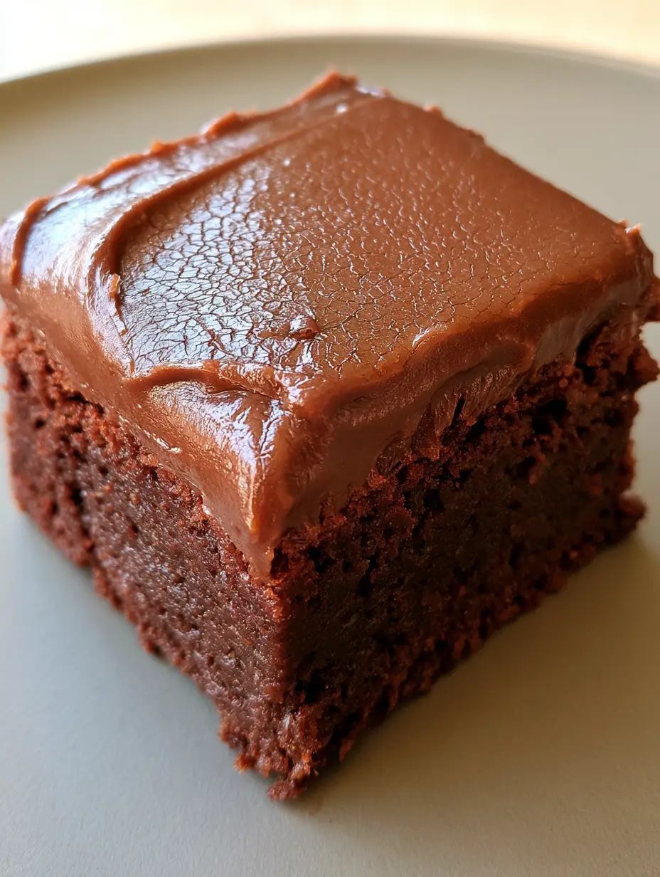 Lunch Lady Brownies: The Ultimate Nostalgic Crackle-Top Recipe 4 High-angle close-up of a single thick Lunch Lady Brownie showing the dense cocoa cake and semi-glossy frosting layer.