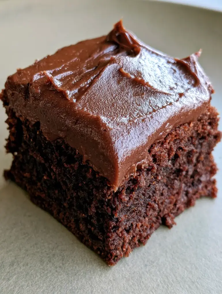 Lunch Lady Brownies: The Ultimate Nostalgic Crackle-Top Recipe 1 A square-cut chocolate brownie with a smooth fudge frosting and thin crackled sugar crust presented on a neutral flat surface.