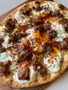 Overhead view of a toasted Hot Honey Pizza featuring charred naan crust and creamy white ricotta dollops.